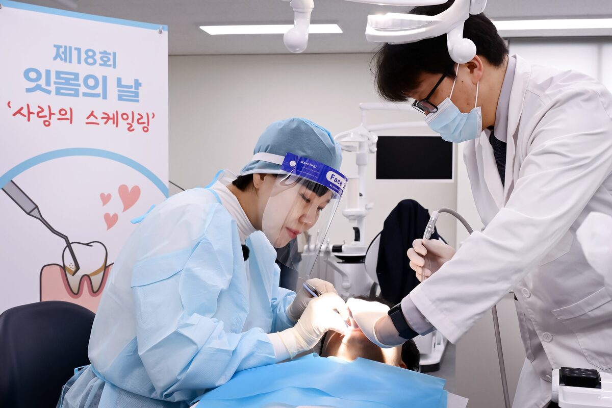 사랑의 스케일링 홍보대사로 위촉된 전현희 국회의원이 의료 전문가로서 진료복을 입고 직접 스케일링 봉사활동에 동참하고 있다. 동국제약 제공