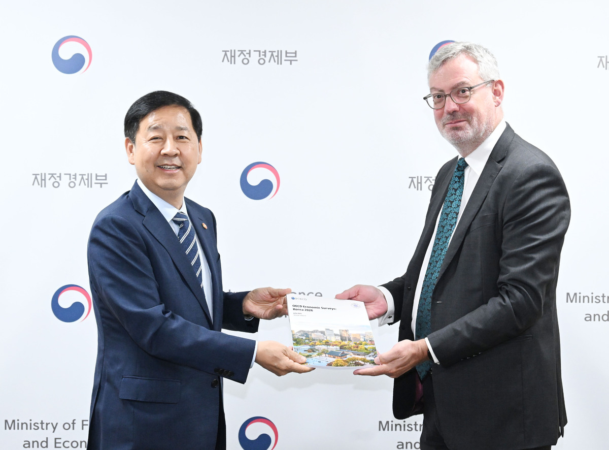 구윤철 부총리 겸 재정경제부 장관(왼쪽)이 지난 1일 서울 종로구 서울청사에서 경제협력개발기구(OECD) 방한단과 면담에 앞서 더글라스 서더랜드 방한단 대표와 ‘2026년 한국경제보고서’를 들고 기념사진을 찍고 있다. 재정경제부 제공