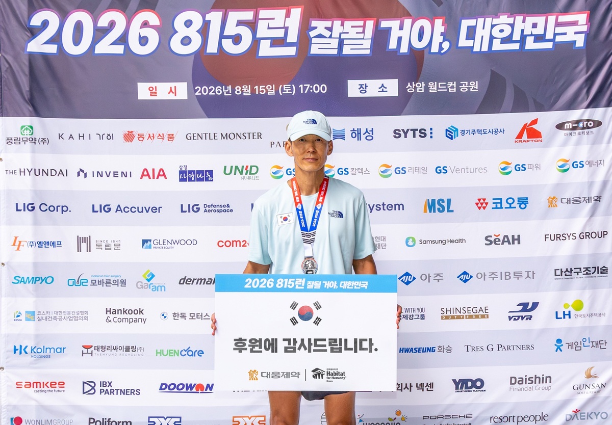 가수 션이 ‘815런’ 81.5㎞ 완주 이후 대웅제약의 후원 감사 보드를 들고 기념사진을 찍고 있다. 대웅제약 제공