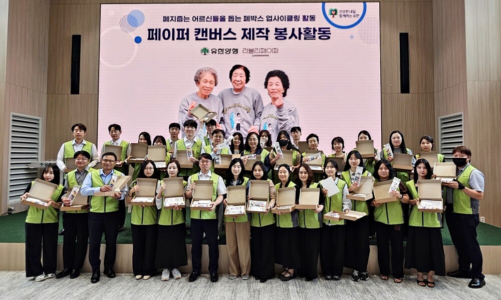 유한양행 임직원들이 친환경 페이퍼 캔버스 제작 봉사활동을 하고 기념사진을 찍고 있다. 유한양행 제공