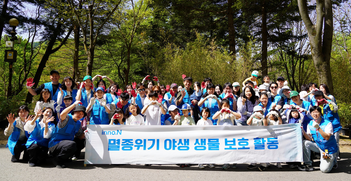 HK이노엔 임직원과 가족들이 레서판다 먹이숲 조성 활동 기념사진을 촬영하고 있다. HK이노엔 제공