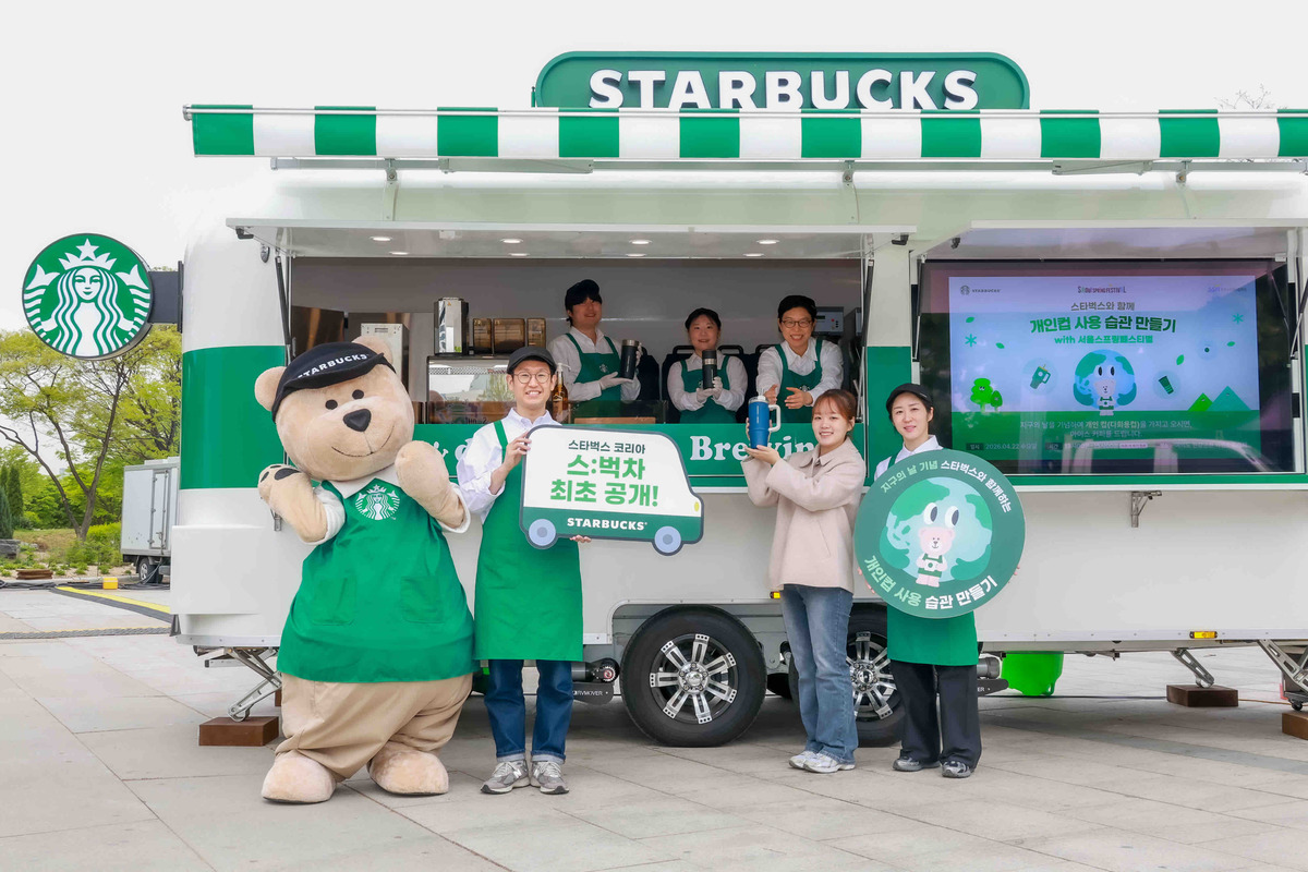 스타벅스 코리아가 22일 지구의 날을 맞이해&nbsp;여의도 한강공원에서 공개한 이동형 커피 트레일러 스:벅차 앞에서 모델과 마스코트가 기념사진을 찍고 있다. 스타벅스 코리아