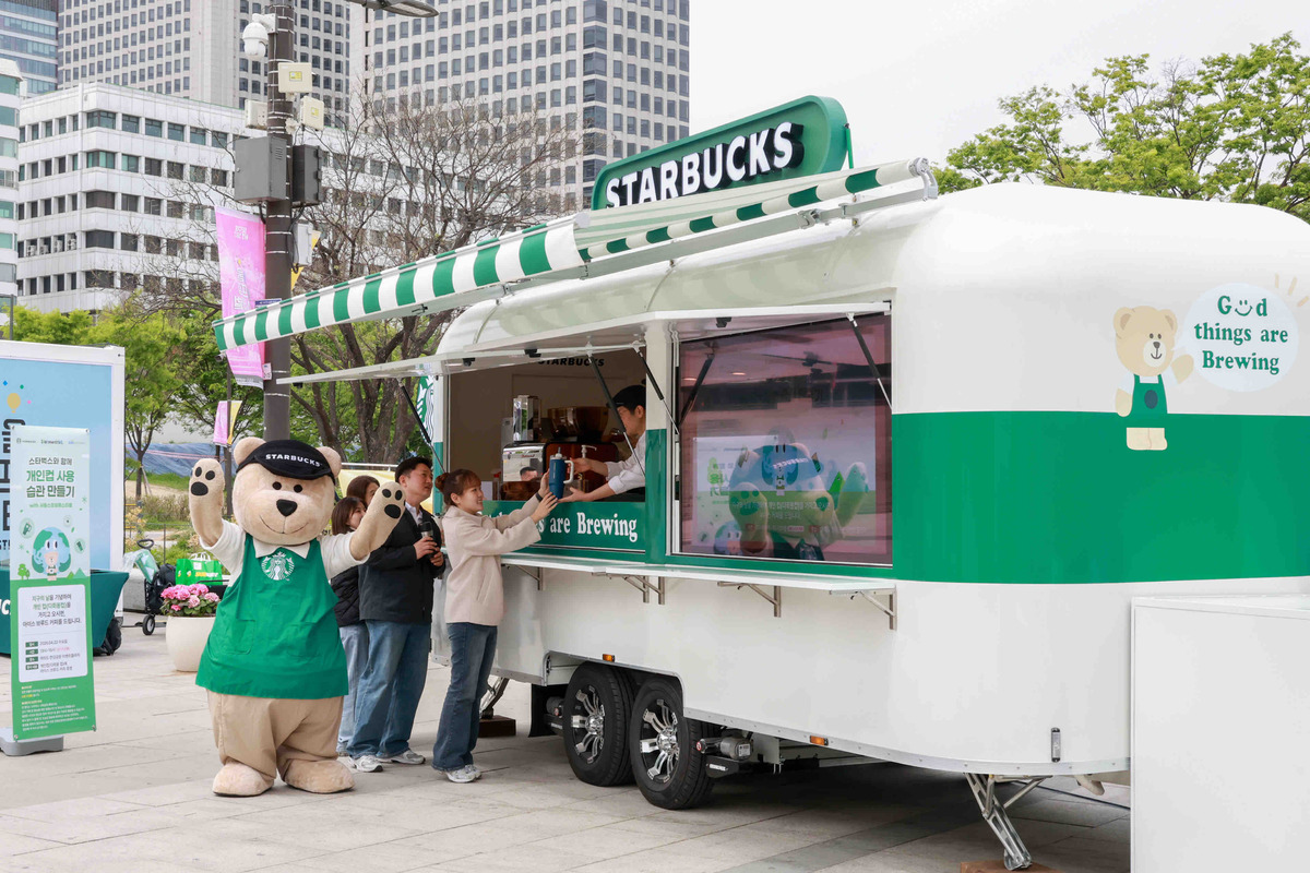 스타벅스 코리아의 이동형 커피 트레일러 스:벅차에서 사람들이 개인 컵에&nbsp;커피를 받고 있다. 스타벅스 코리아 제공