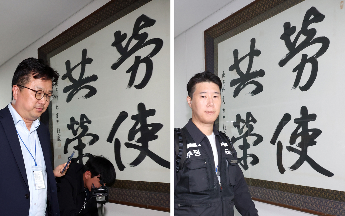삼성전자 노사 대표교섭위원인 최승호 초기업노조 삼성전자지부 위원장(오른쪽)과 김형로 부사장이 13일 2차 사후조정회의를 마친 뒤 정부세종청사 중앙노동위원회에 붙은 노사공영&nbsp;액자 앞을 지나치고 있다. 뉴시스