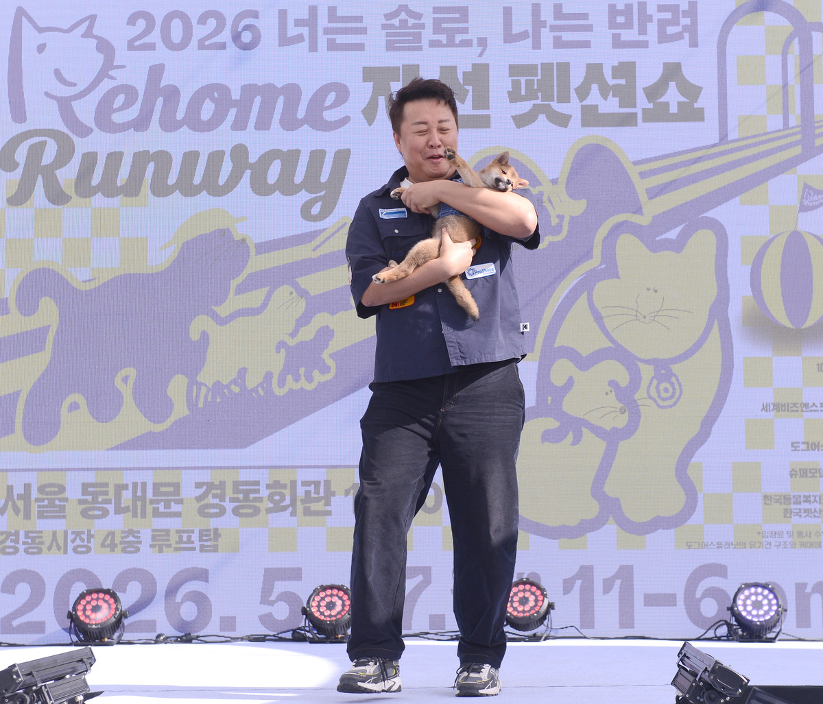 BYC 개리야스 제품을 입은 강아지 ‘포비’가 코미디언 겸 배우 정준하 씨의 품에 안겨 런웨이를 걷고 있다. 포비는 런웨이를 마친 뒤 입양되며 ‘바로’로 견생2막을 열었다. 김두홍 기자